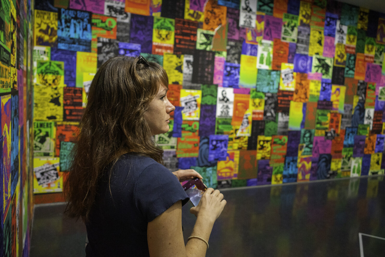 Photographing a wall of community posters and printed art